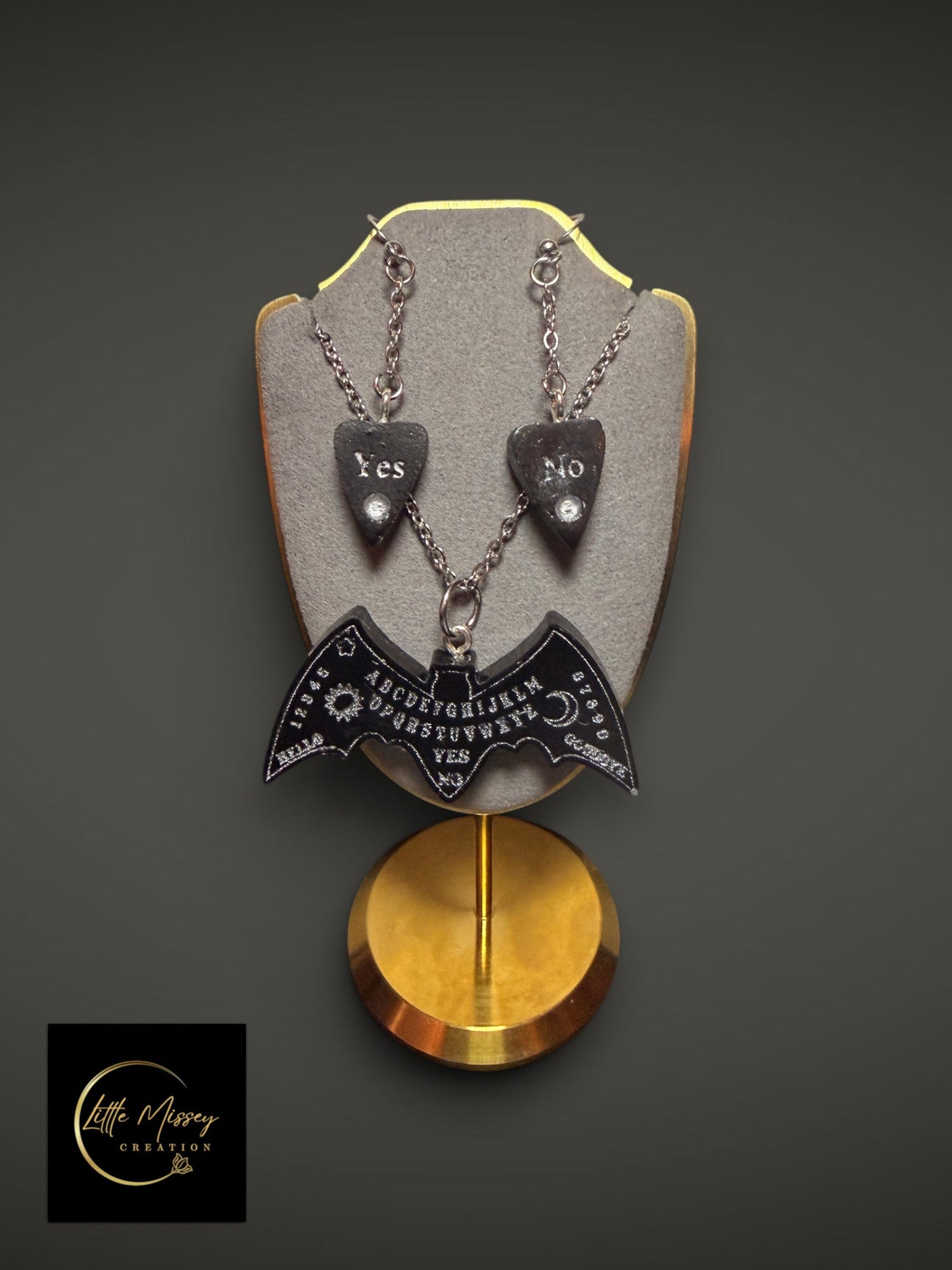 Little Missey Creation gothic spirit board bat necklace and planchette earrings set in black resin on a display stand