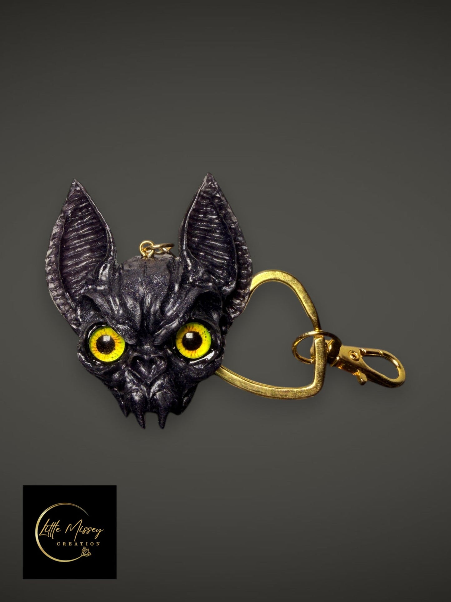 Little Missey Creation handcrafted bat-like fantasy creature keychain with striking yellow eyes and gold heart clasp.