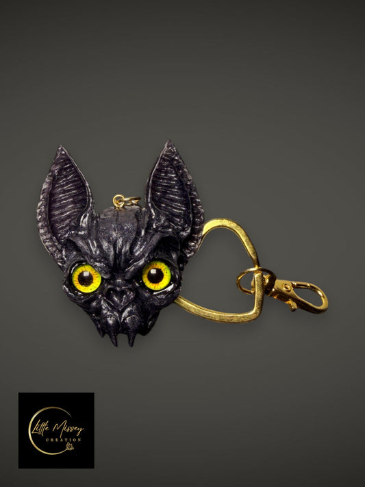 Little Missey Creation handcrafted bat-like fantasy creature keychain with striking yellow eyes and gold heart clasp.