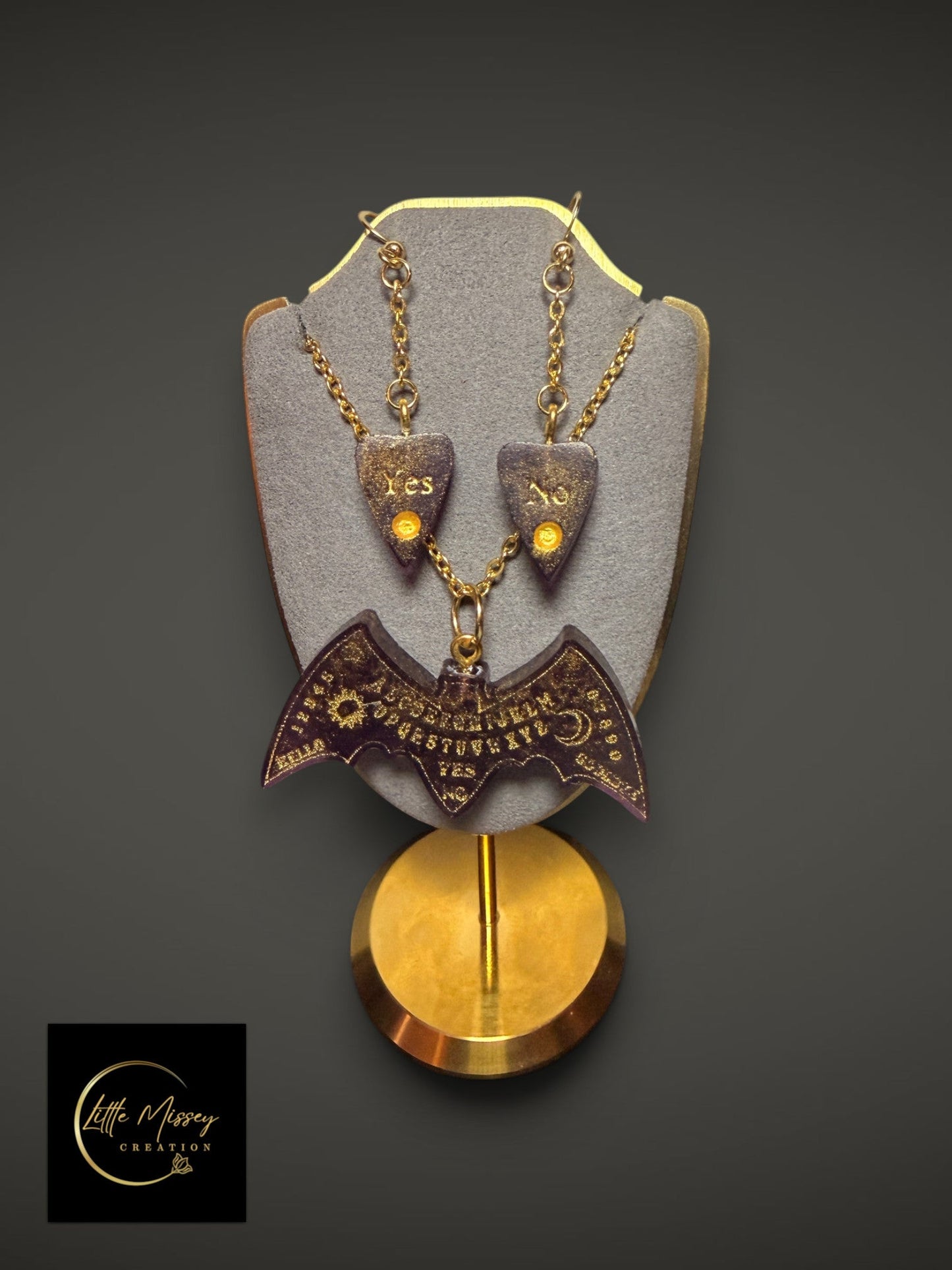 Little Missey Creation gothic spirit board bat necklace and planchette earrings set in dark resin with gold accents.