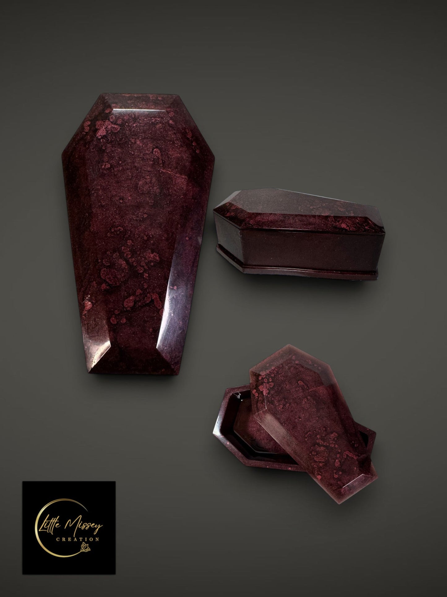 Little Missey Creation coffin-shaped resin trinket boxes in a deep burgundy marbled finish on a dark background.