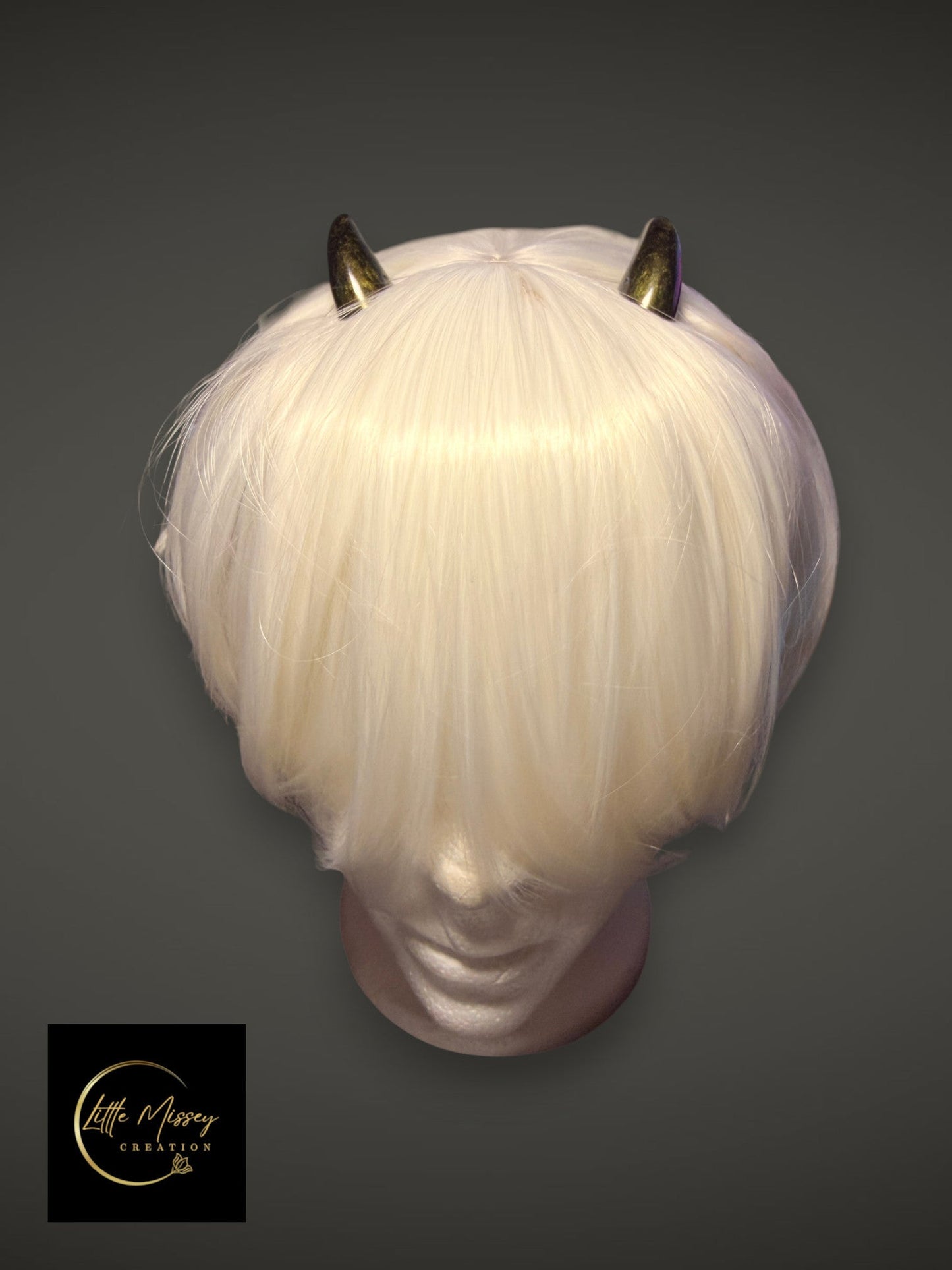 Little Missey Creation handcrafted metallic gold demon horns styled on a white cosplay wig for a fantasy character.
