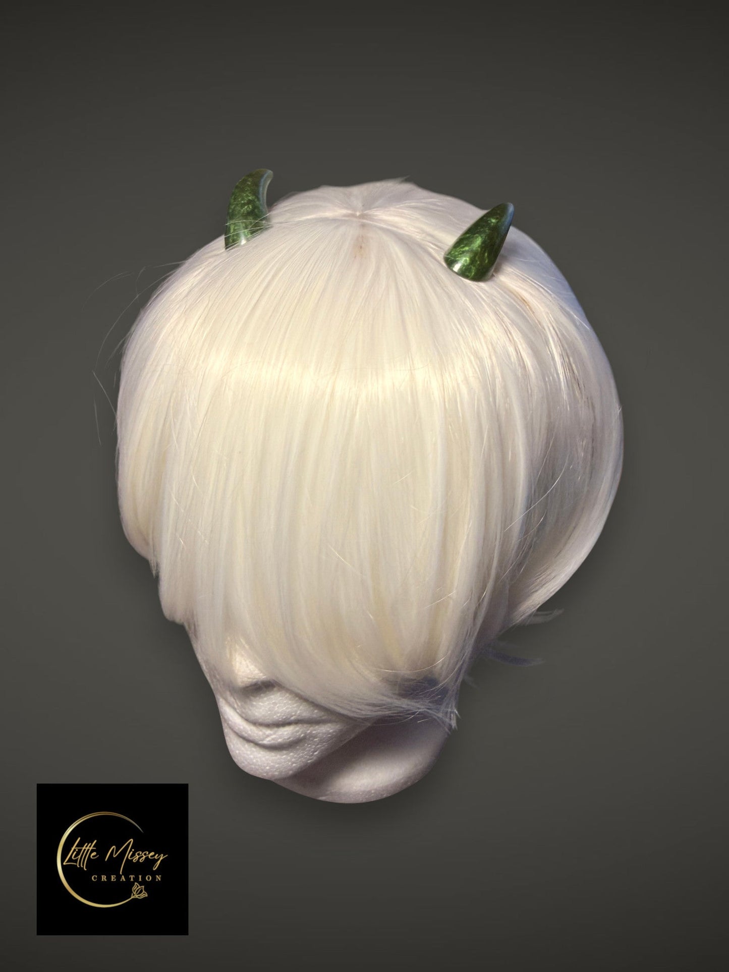 Little Missey Creation green marbled cosplay horns attached to a short white wig on a mannequin head