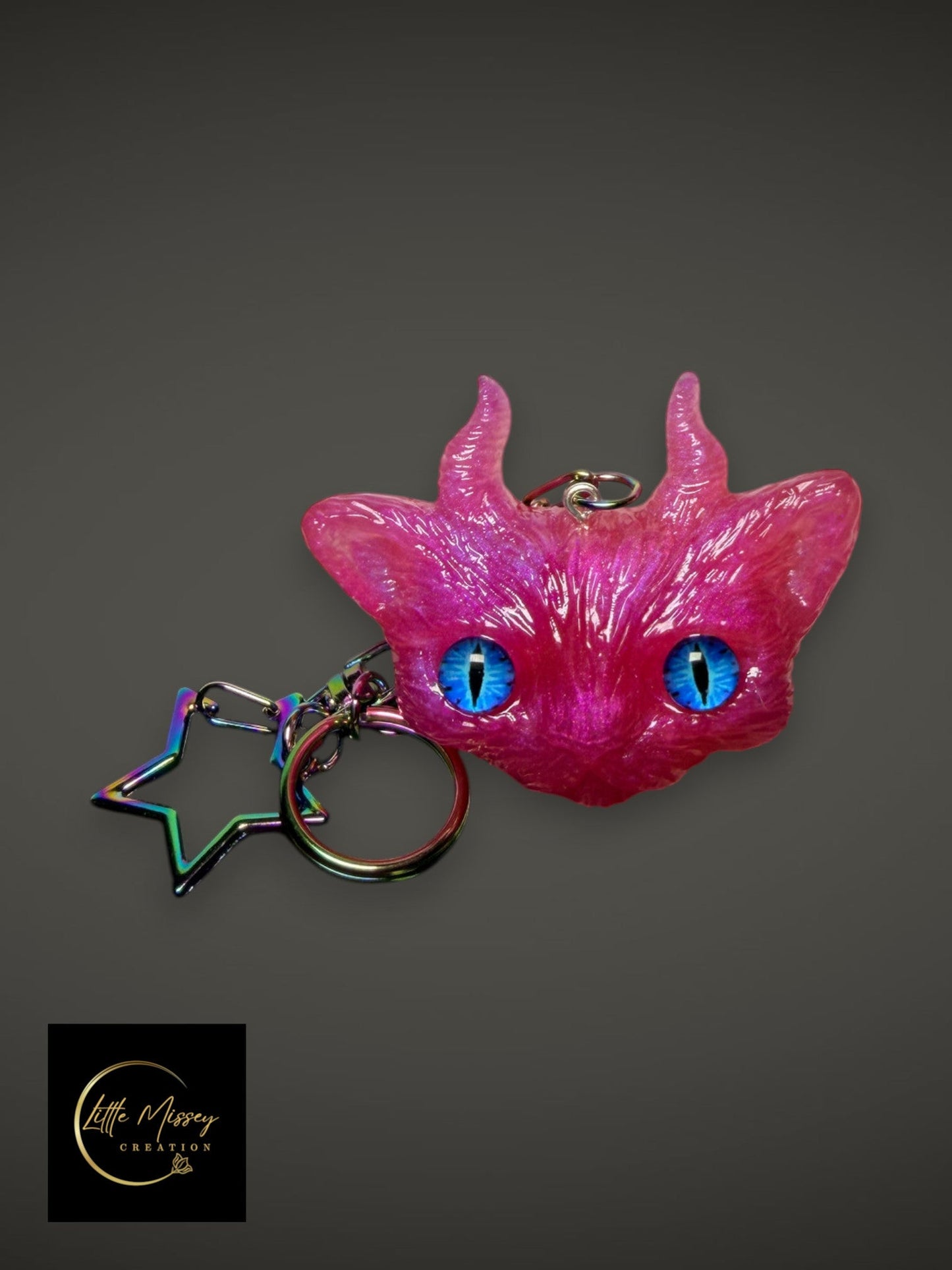 Little Missey Creation pink horned fantasy creature keychain with vibrant blue lifelike eyes and a star-shaped clasp