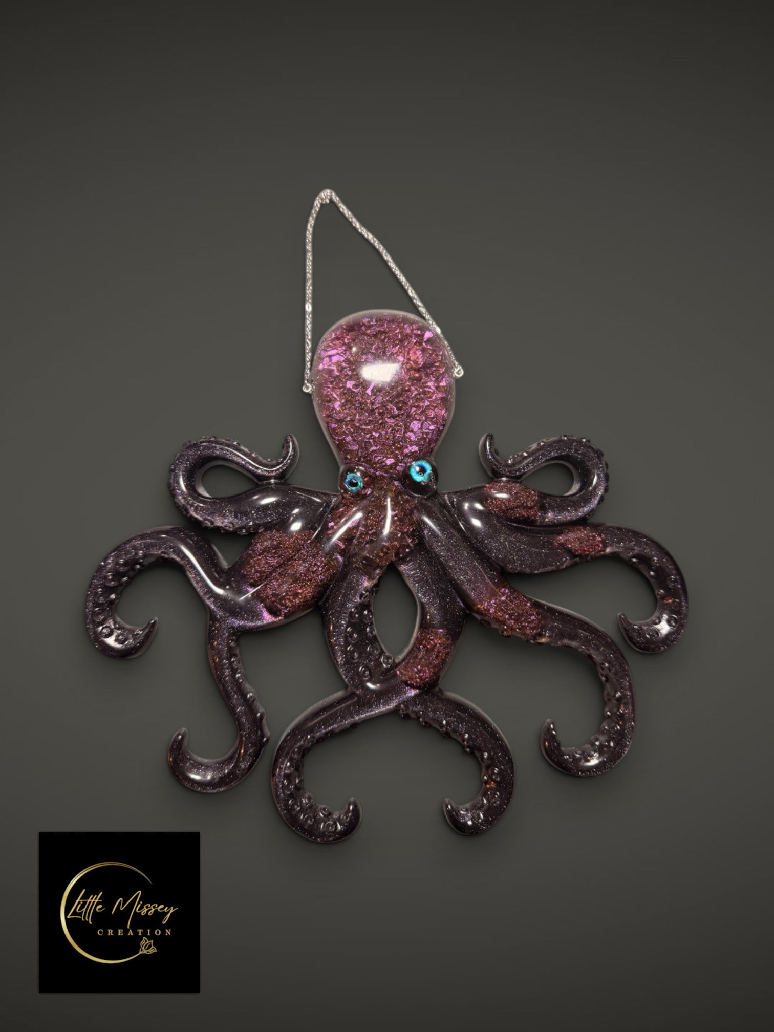 Little Missey Creation purple resin octopus wall hanging with glitter accents and vibrant blue eyes on a grey background