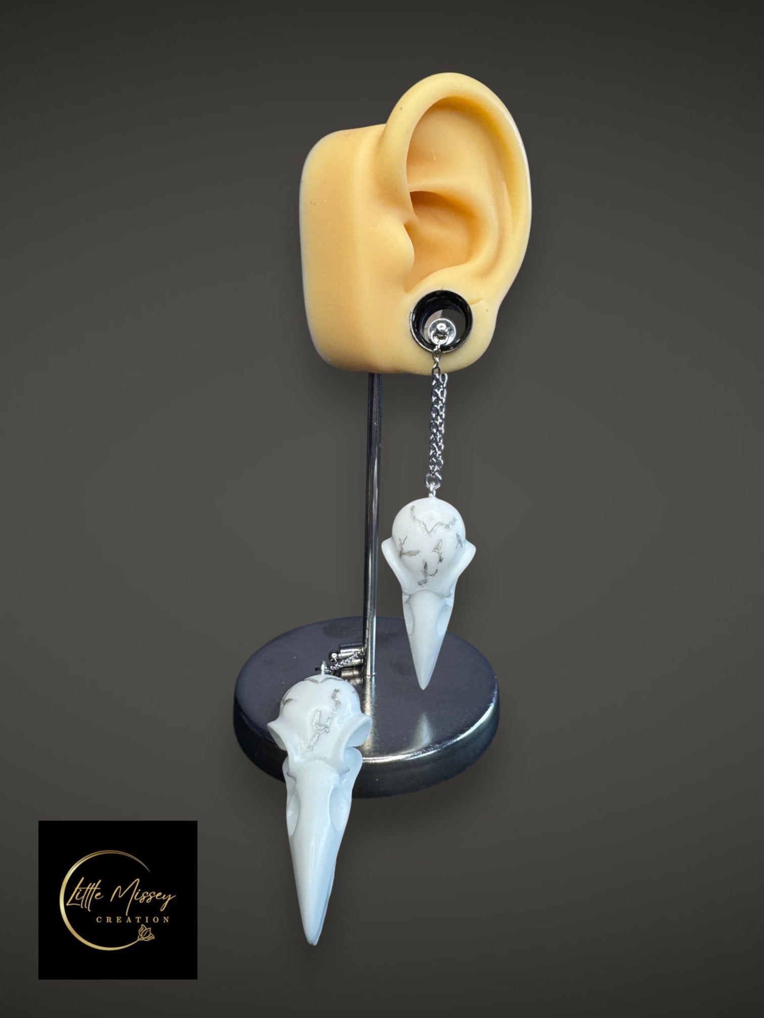 Resin raven skull dangle earrings adapted for those who wear gauges.