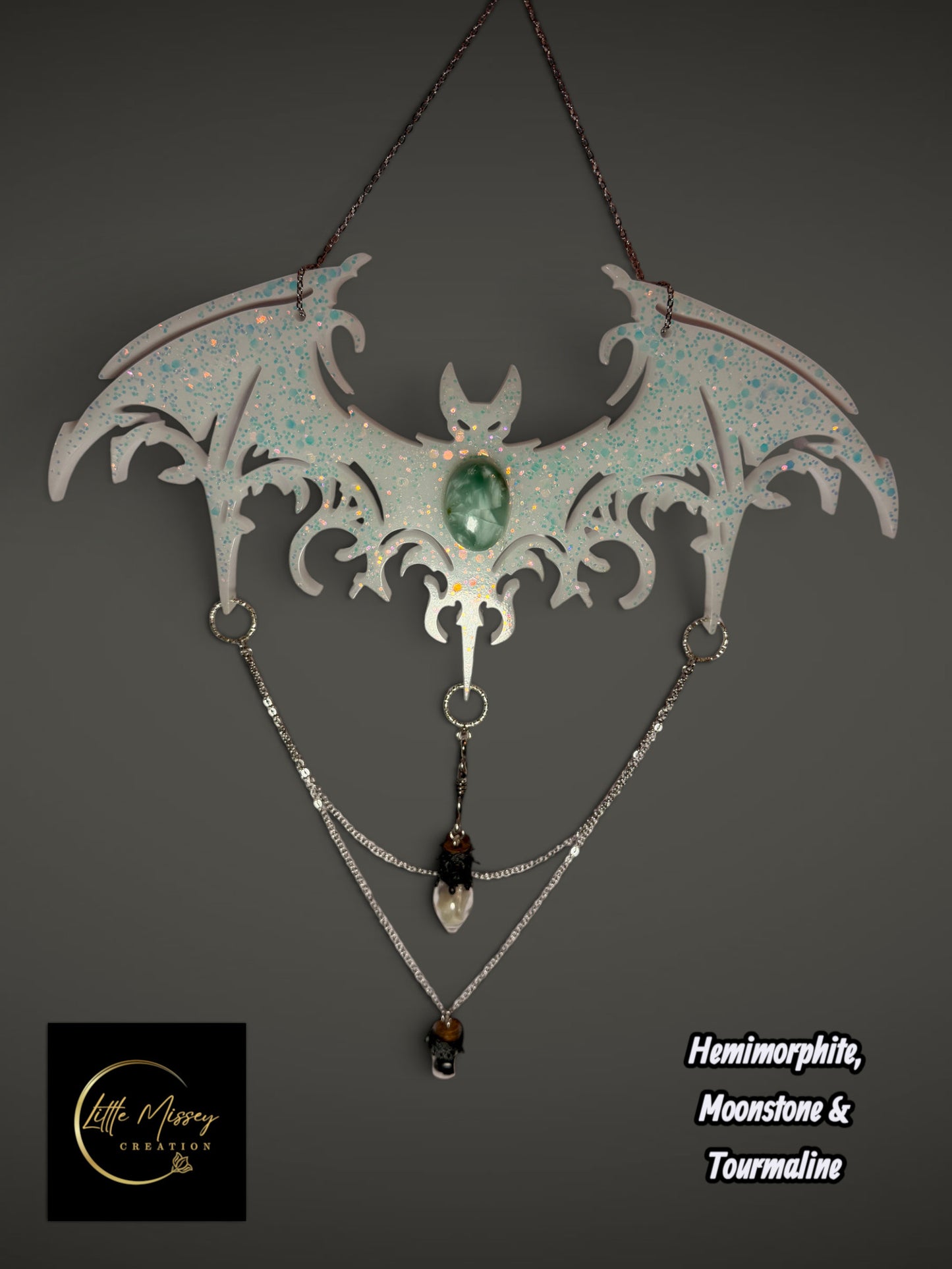 Little Missey Creation handcrafted resin bat wall hanging with iridescent glitter, hemimorphite, moonstone, and chains.