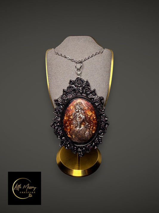 Little Missey Creation ornate Victorian style cameo pendant necklace with a black floral frame and amber resin inlay.